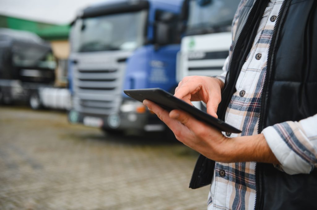 man using digital tablet in front of heavy freight 2026 07 11 02 53 51 utc 1